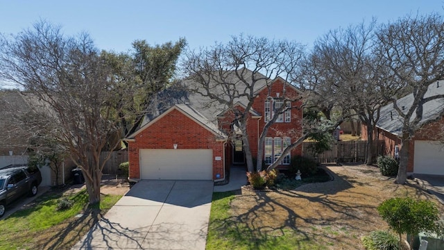 traditional home featuring concrete driveway, brick siding, an attached garage, and fence