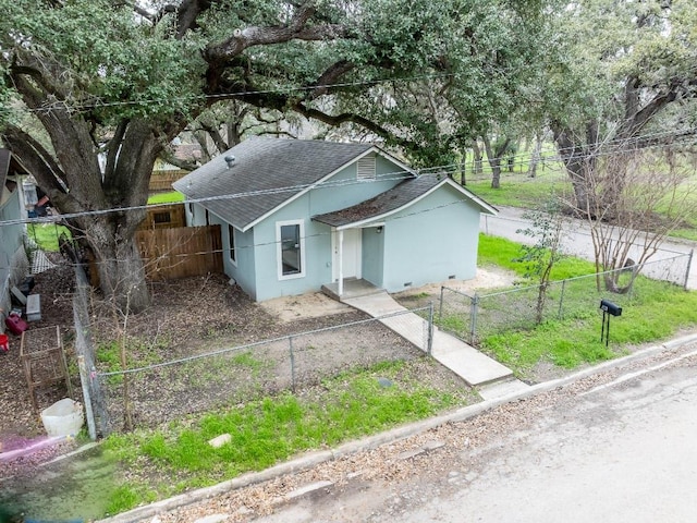 view of front of house featuring fence private yard, a gate, stucco siding, and roof with shingles