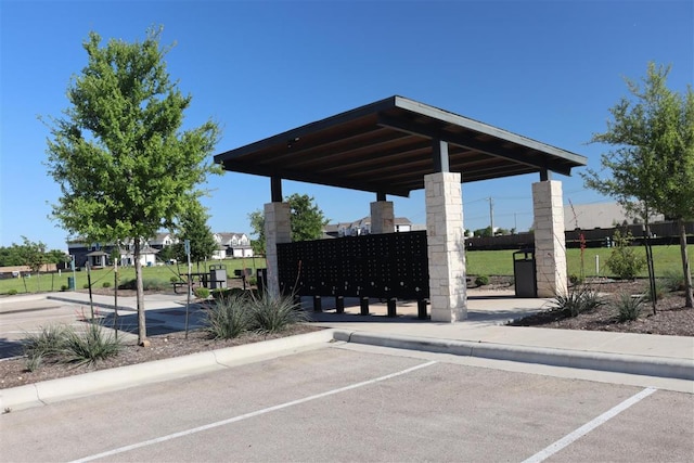 view of home's community featuring uncovered parking, fence, and mail area