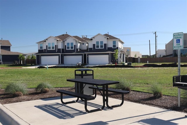 view of front of house featuring board and batten siding, fence, and a front lawn