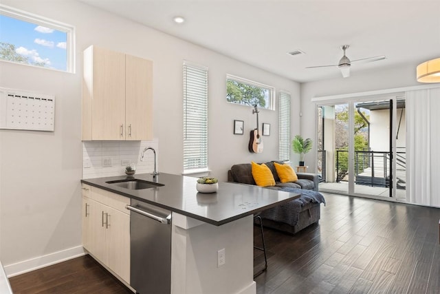 kitchen with dark wood-style flooring, visible vents, backsplash, a sink, and a peninsula