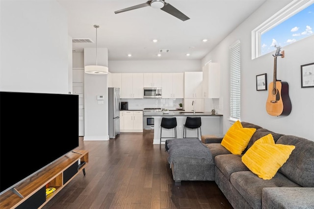 living room with visible vents, dark wood finished floors, a ceiling fan, and recessed lighting