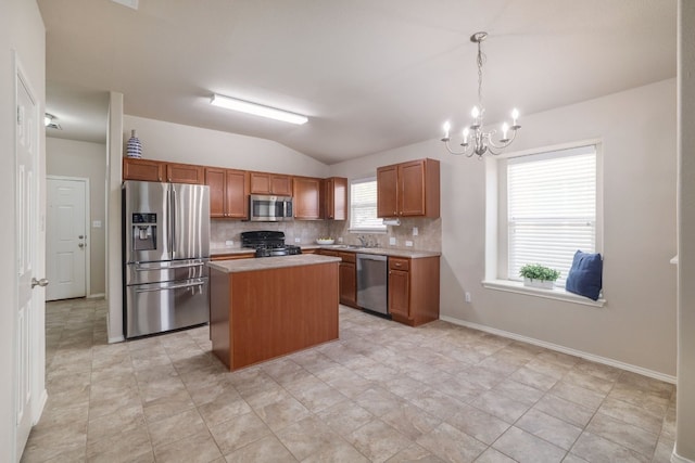 kitchen featuring lofted ceiling, appliances with stainless steel finishes, brown cabinets, light countertops, and backsplash