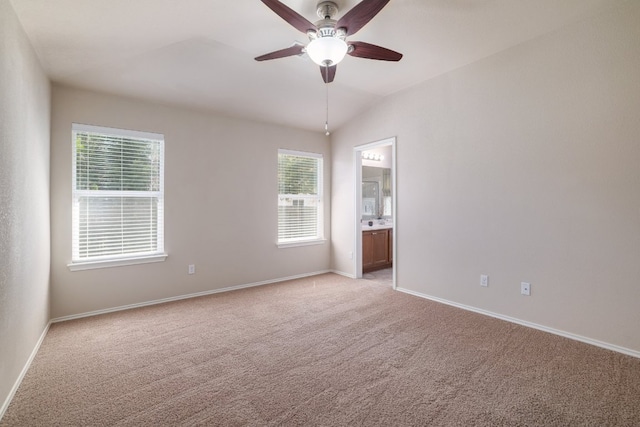 empty room featuring light carpet, ceiling fan, baseboards, and lofted ceiling