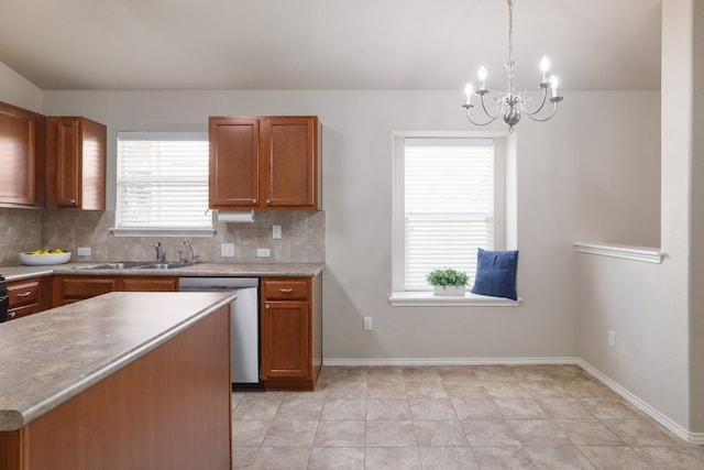 kitchen with tasteful backsplash, brown cabinetry, a sink, and stainless steel dishwasher