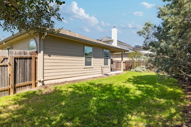 back of property with a lawn, a chimney, and fence