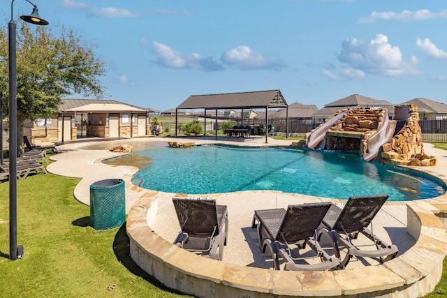 view of swimming pool featuring a water slide, an outdoor fire pit, fence, a gazebo, and a patio area