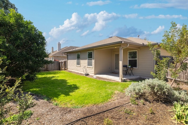 back of property with a fenced backyard, a patio, and a lawn