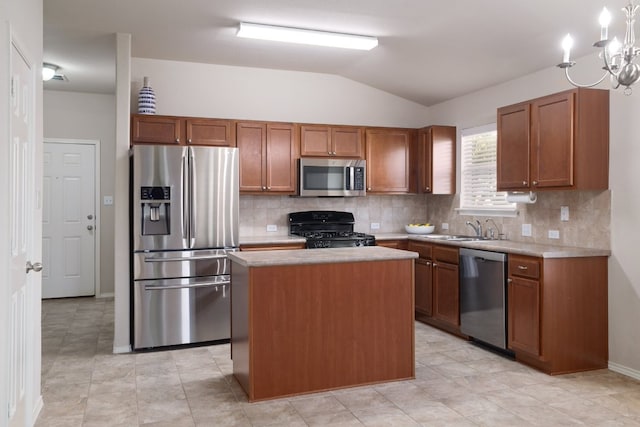 kitchen featuring light countertops, appliances with stainless steel finishes, vaulted ceiling, a sink, and a kitchen island