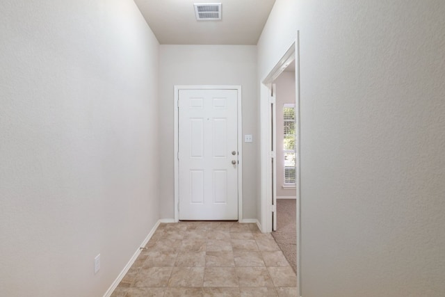 doorway to outside with visible vents, baseboards, and light tile patterned floors