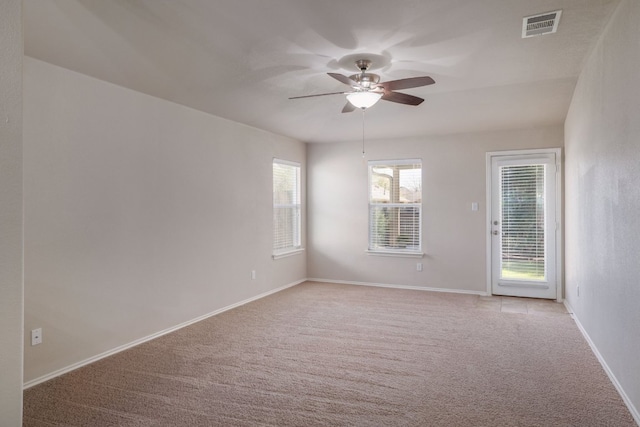 unfurnished room with baseboards, visible vents, a ceiling fan, and light colored carpet