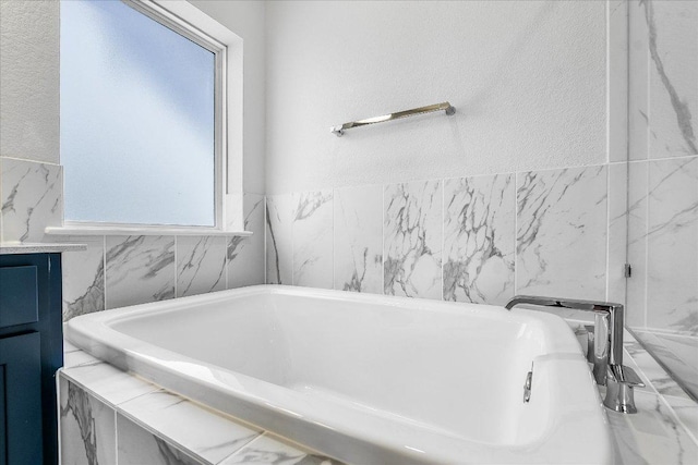 842 Nadal Path, Round Rock, TX 78664 - bathroom featuring a tub to relax in, tile walls, and vanity
