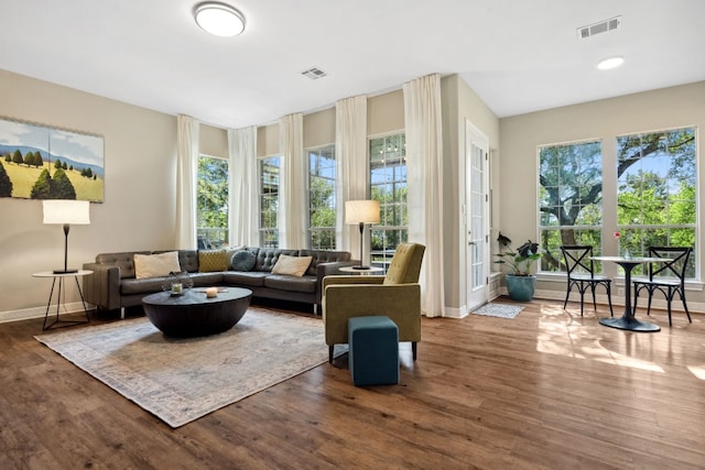 living area featuring visible vents, plenty of natural light, and wood finished floors