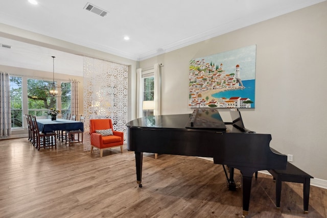 sitting room with recessed lighting, a notable chandelier, wood finished floors, visible vents, and crown molding