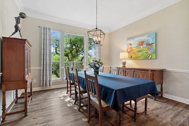 dining room featuring an inviting chandelier, baseboards, crown molding, and wood finished floors