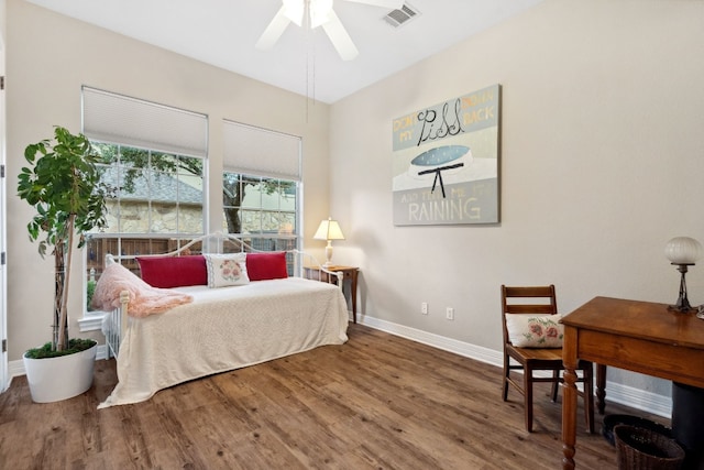 bedroom with wood finished floors, visible vents, and baseboards