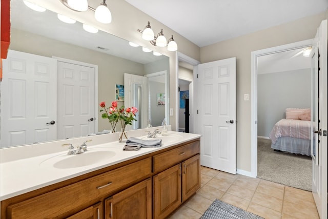 ensuite bathroom with tile patterned flooring, visible vents, a sink, and double vanity