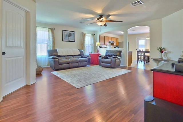 living room featuring a wealth of natural light, visible vents, and wood finished floors