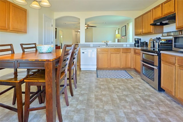 kitchen featuring stainless steel appliances, light countertops, a ceiling fan, a sink, and under cabinet range hood