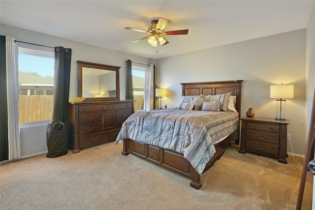 carpeted bedroom featuring multiple windows and a ceiling fan