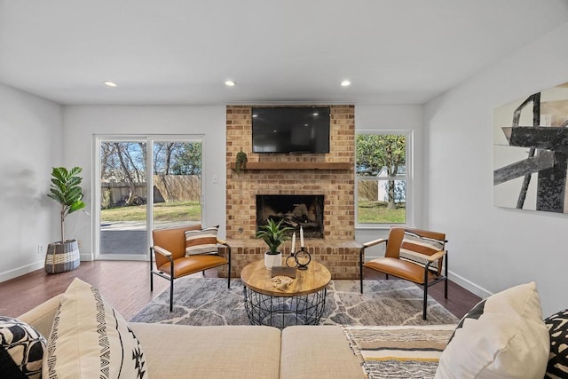 living room featuring a fireplace, baseboards, wood finished floors, and recessed lighting