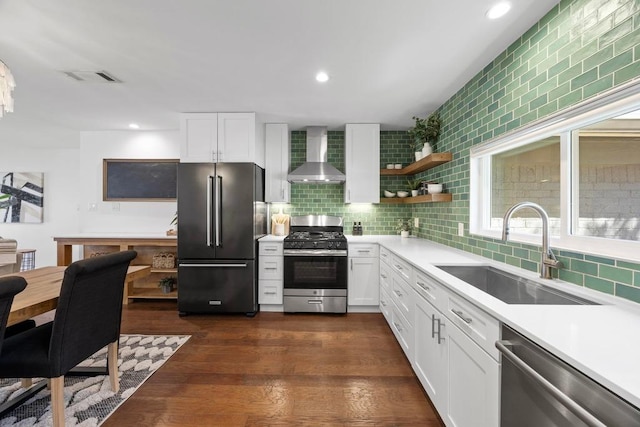 kitchen featuring light countertops, visible vents, appliances with stainless steel finishes, a sink, and wall chimney range hood