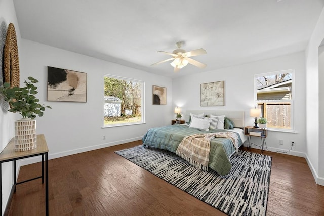 bedroom with a ceiling fan, baseboards, and wood finished floors