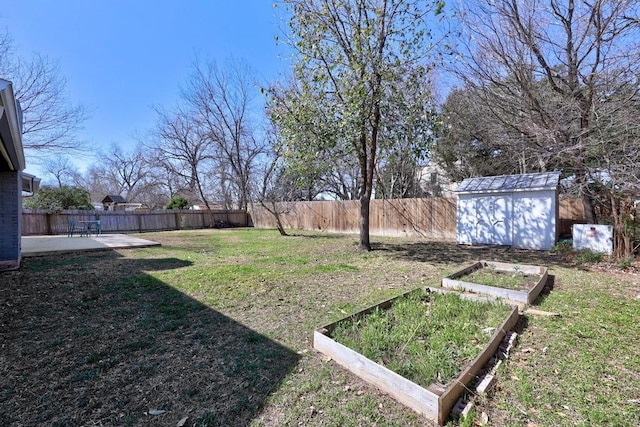 view of yard with an outbuilding, a patio, a fenced backyard, a vegetable garden, and a shed