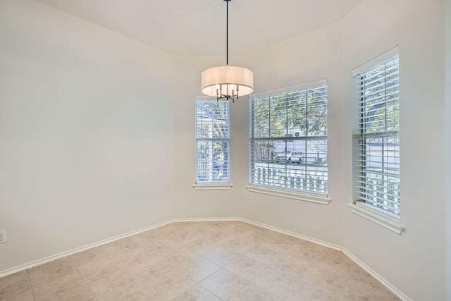 empty room featuring light tile patterned floors and baseboards