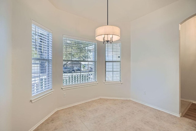 unfurnished room featuring light tile patterned floors, plenty of natural light, and baseboards