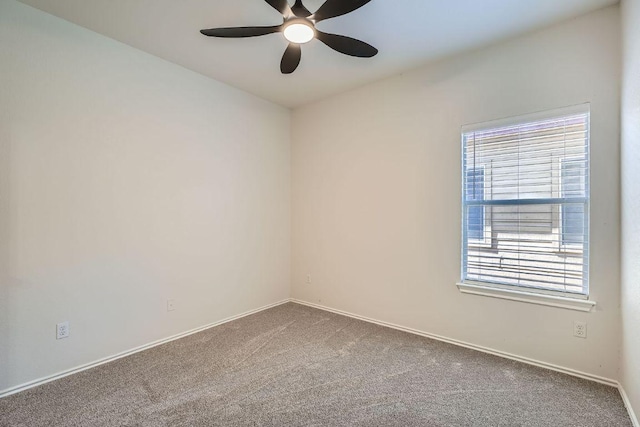 carpeted empty room with a ceiling fan and baseboards