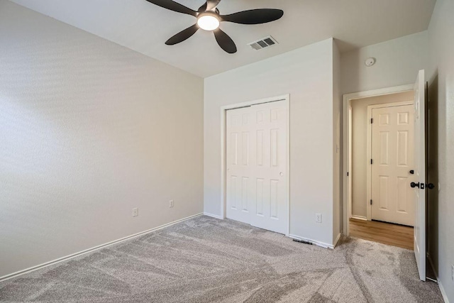 unfurnished bedroom with a closet, carpet, visible vents, and baseboards