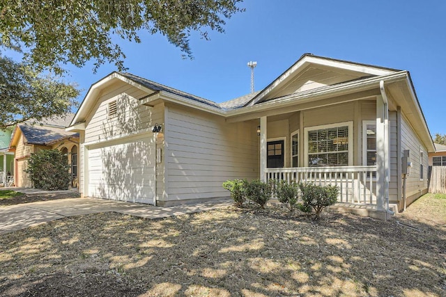 ranch-style home featuring a porch, concrete driveway, and a garage