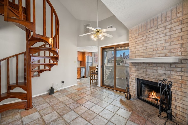 living room featuring visible vents, baseboards, ceiling fan, stairway, and a brick fireplace