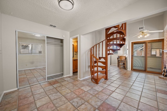 entryway with stairway, baseboards, visible vents, and ceiling fan