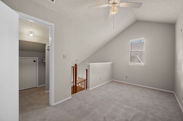 bonus room with carpet, baseboards, vaulted ceiling, and a textured ceiling