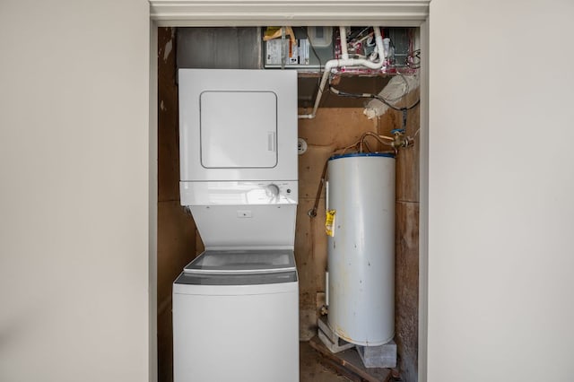 washroom featuring stacked washer and dryer, gas water heater, and laundry area