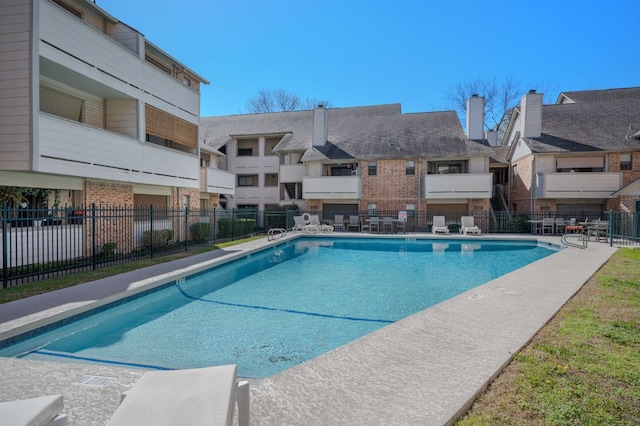 community pool with fence and a patio