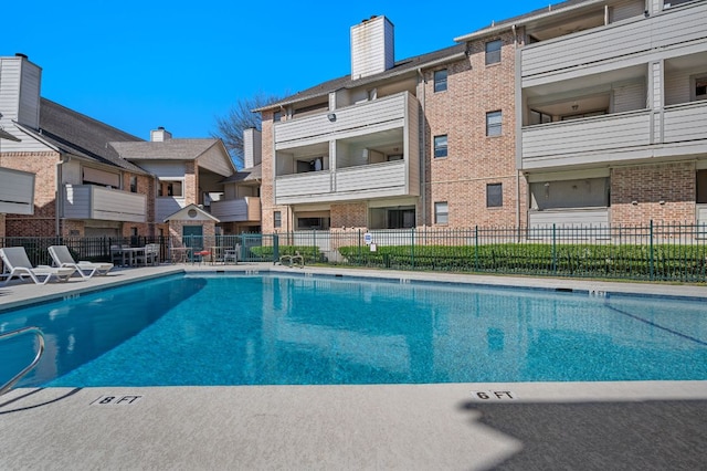 view of swimming pool featuring a patio area and fence