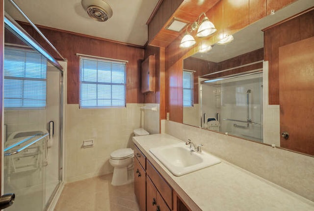 full bathroom featuring tile walls, toilet, a shower stall, and vanity