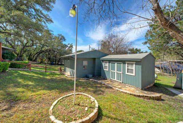 5600 Lakeview Dr, Austin, TX 78734 - back of house featuring an outbuilding, fence, and a lawn