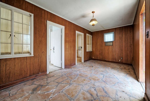 5600 Lakeview Dr, Austin, TX 78734 - spare room with crown molding, wood walls, baseboards, and stone finish flooring