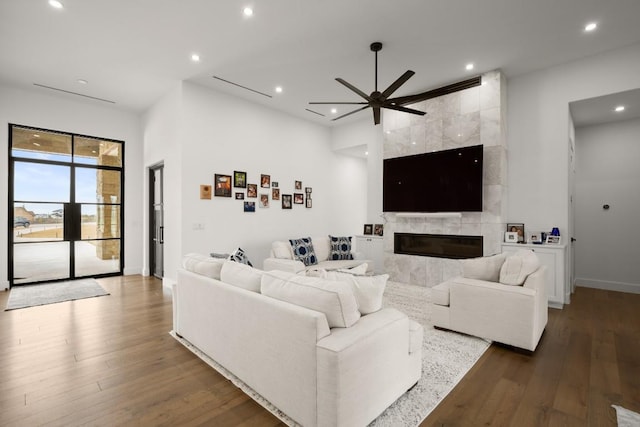 living room featuring recessed lighting, ceiling fan, wood finished floors, and a tile fireplace