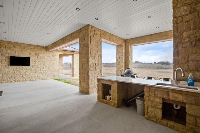 view of patio featuring an outdoor kitchen and a sink