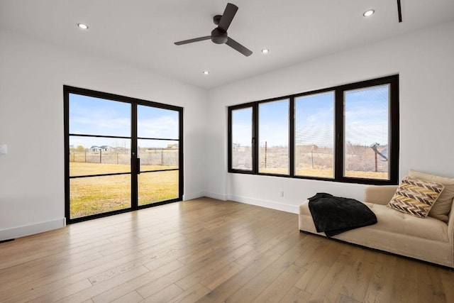 unfurnished living room with ceiling fan, recessed lighting, hardwood / wood-style flooring, and baseboards