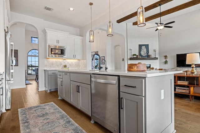 kitchen featuring arched walkways, gray cabinets, visible vents, appliances with stainless steel finishes, and open floor plan