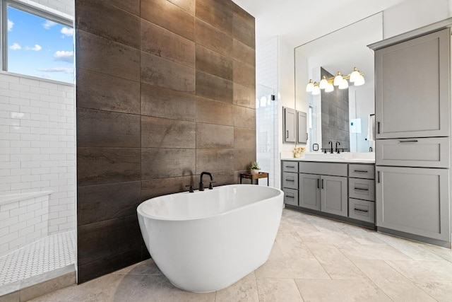 full bath featuring a soaking tub, tile walls, vanity, and a walk in shower