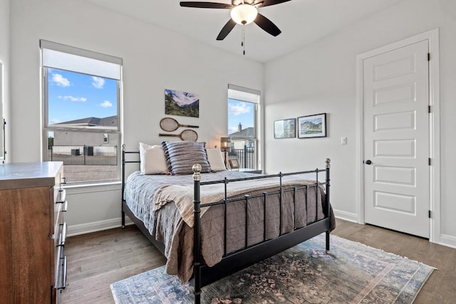 bedroom featuring ceiling fan, baseboards, and wood finished floors