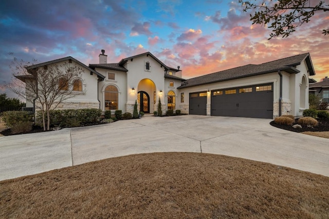 view of front of house featuring concrete driveway, stone siding, a chimney, an attached garage, and stucco siding