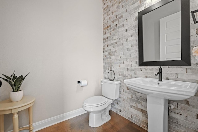 bathroom featuring wood finished floors, toilet, and baseboards